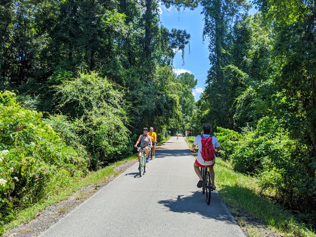 Cyclists pass each other on a tree-lined bike path