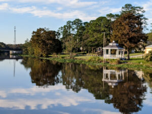 A gazebo on the banks of the bayou is reflected in the water on a weekend in New Iberia