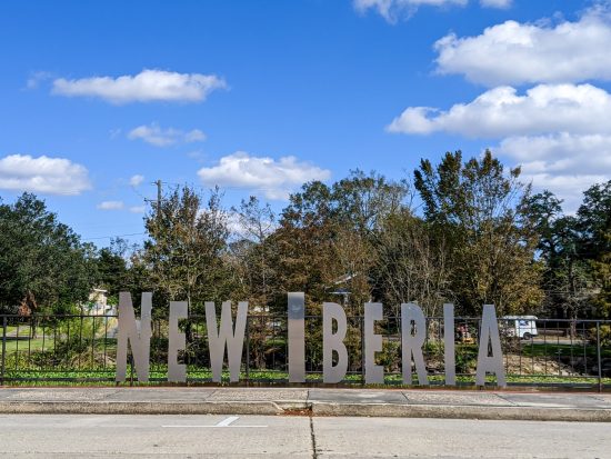 A large silver New Iberia sign overlooks the bayou on a weekend getaway in New Iberia.
