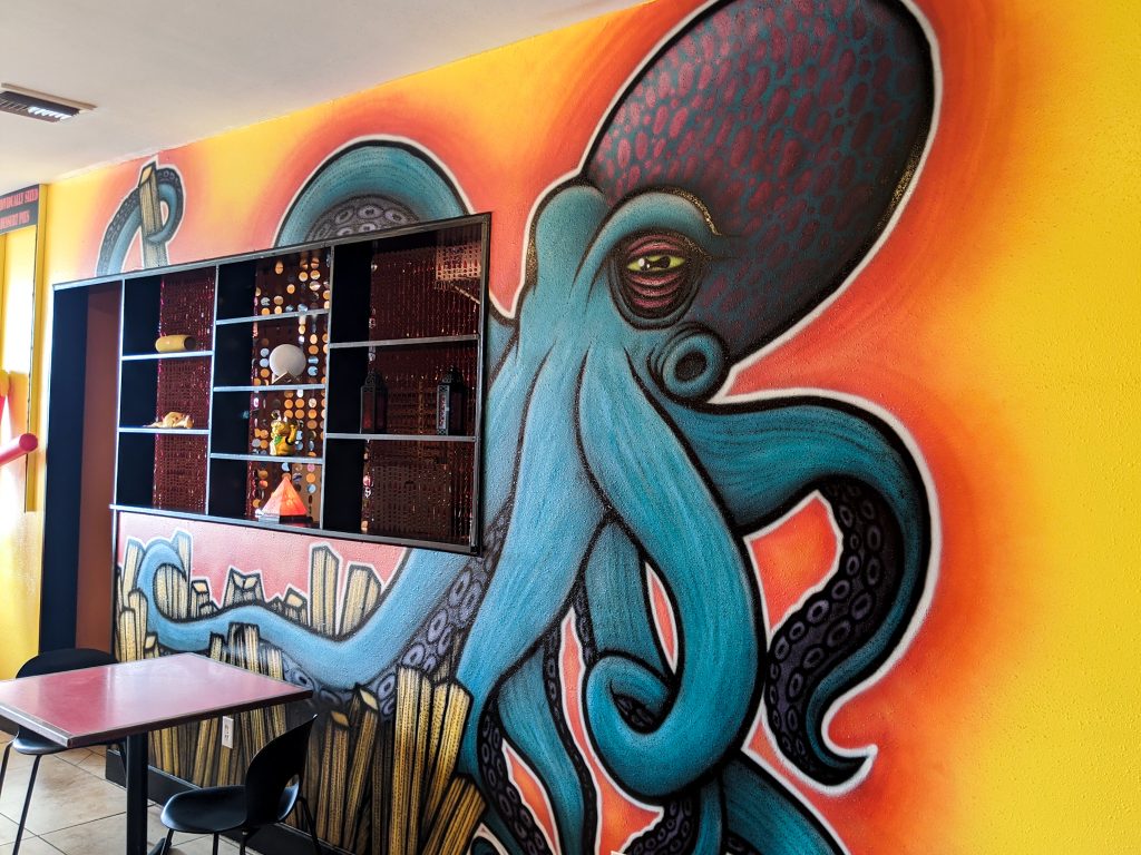 A mural of a blue and purple octopus on the wall of a restaurant on a day trip to St. Bernard Parish